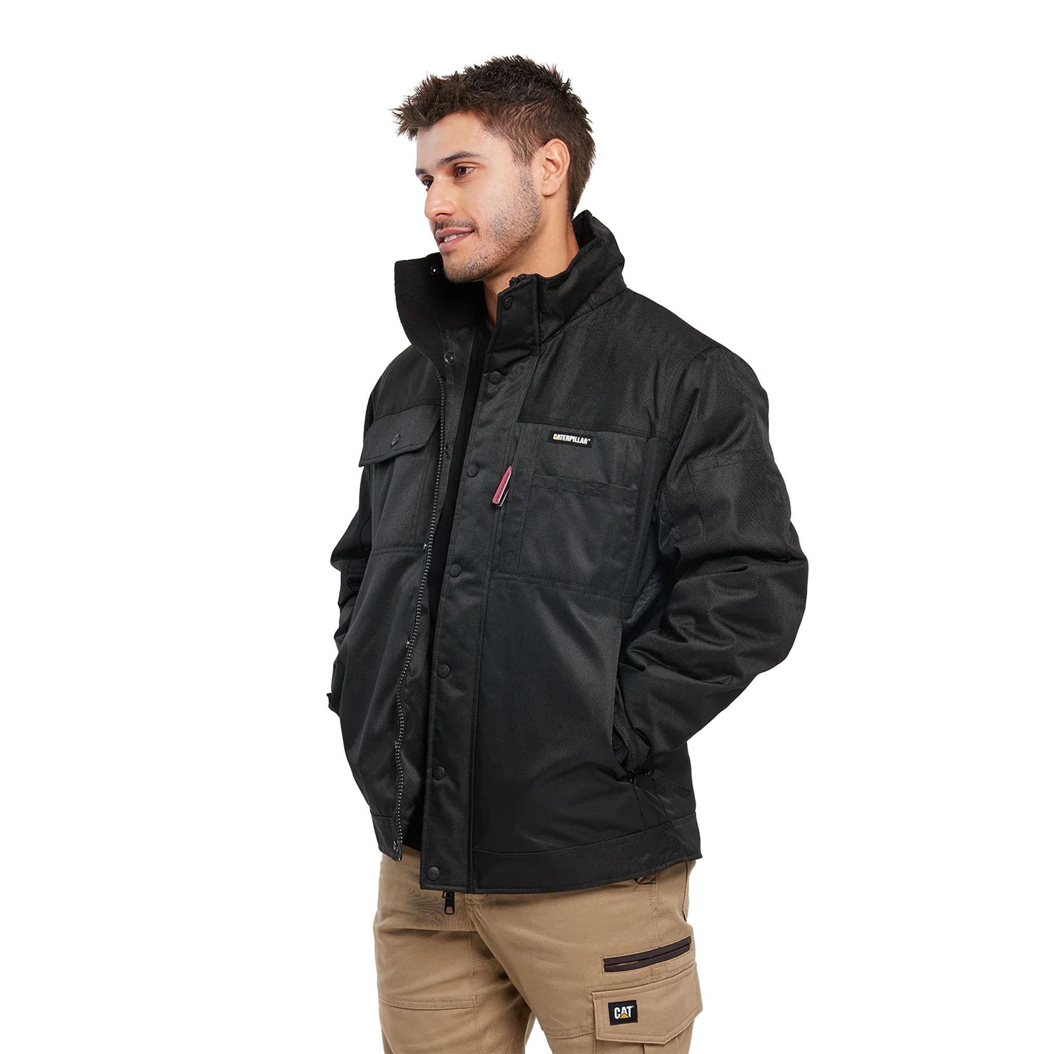 A man wearing a black technical jacket with a high collar, zippered front, and flap chest pockets, paired with tan cargo pants, photographed against a solid white background.