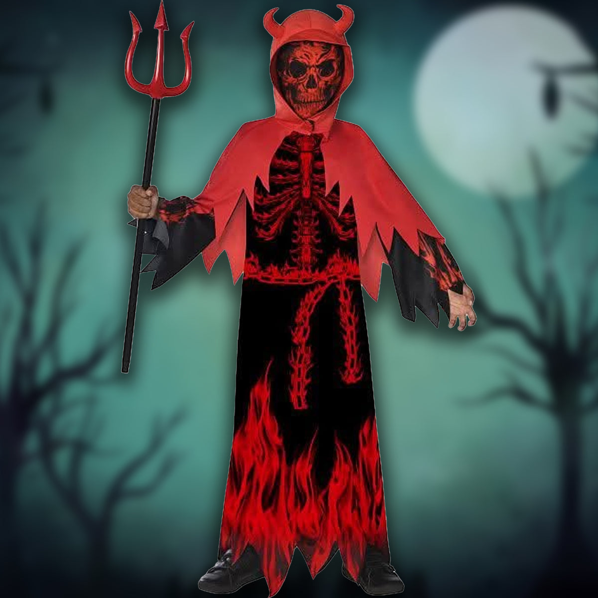 A child wearing a red and black devil Halloween costume with a skull mask, horned hood, cape, and long robe with flame details, holding a red trident against a spooky moonlit background.