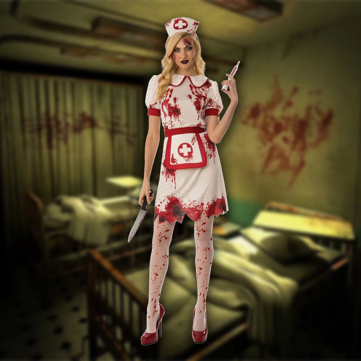 A woman modeling a bloody nurse Halloween costume in a hospital room setting. The costume includes a white dress with red trim, a matching blood-splattered apron with a red cross, white tights with red splatters, and a nurse hat.