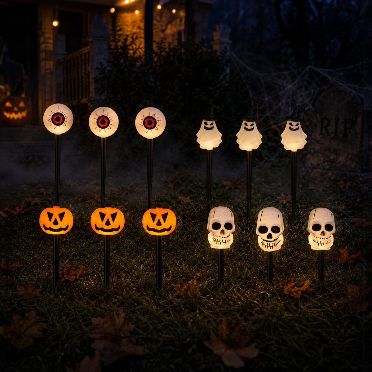 A set of 10 Halloween yard stakes with glowing lights, including four jack-o'-lanterns, four eyeballs, and four skulls, displayed on a grassy lawn in front of a spooky house at night.