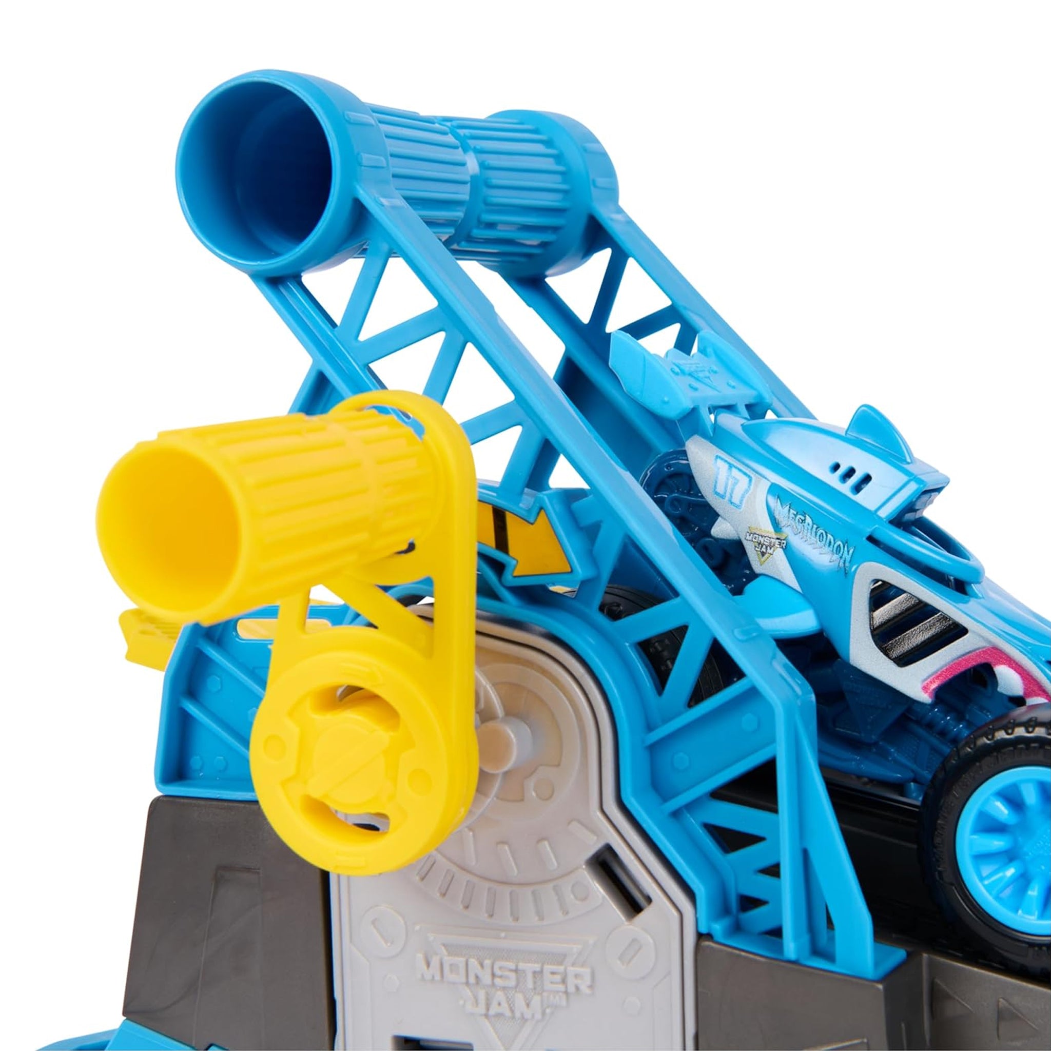 Close-up of a toy vehicle launch ramp set with a blue and white monster truck, bright blue support structure, yellow launch nozzles, and a gray base on a white background.
